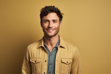 Obraz premium Portrait of a satisfied man in his 20s sporting a versatile denim shirt in front of pastel brown background