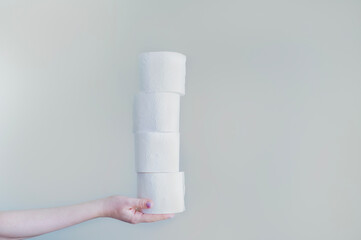 Woman with toilet paper rolls on a gray background, advertising campaigns aimed at raising awareness of the importance of hygiene in public places such as schools, offices, and public restrooms.