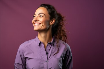 Fototapeta premium Portrait of a blissful woman in her 30s sporting a technical climbing shirt on soft purple background