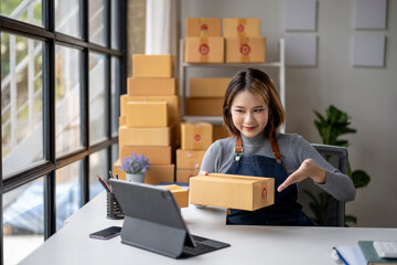 A woman is sitting at a desk with a box in front of her