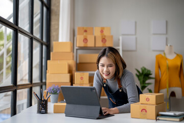 A woman is sitting at a desk with a laptop and a box of flowers in front of her