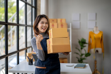 A woman is holding three boxes and smiling