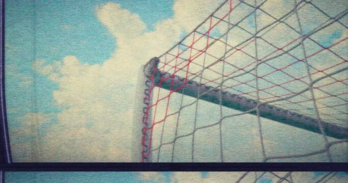 Soccer VHS - A low-angle slow motion shot from the side of the goal showing a soccer ball hitting the net and scoring a goal - retro style. Damaged VHS tape or faulty TV set - VFX