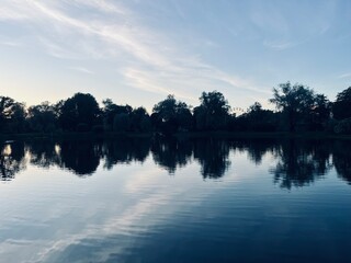 Fototapeta premium twilights at the park, sky and trees silhouettes reflection on the water surface, pond in the park, evening, summer