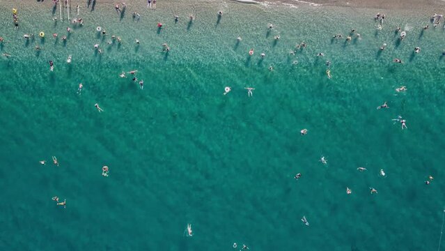 Awesome aerial view of Beach in Kemer, Turkey. Drone flying over the beach and the Mediterranean Sea. People swimming in popular tourist destination