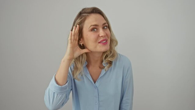 Charming young blonde woman, ears pricked up, all ears to gossip! standing isolated on white, hand cupped to ear, listening for rumors. deafness concept.