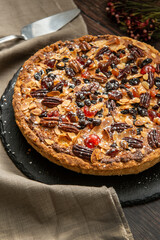 Pecan and cherry tart, on a rustic wooden background