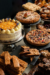 Big table with various cakes, tarts, muffins and pastries. Top view