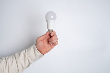 Man holds a light bulb and a clock in his hands. Concept of inspiration, creative idea, thinking and future technological innovation