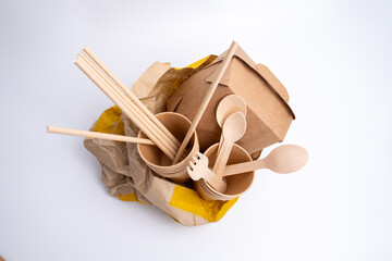 Kraft paper tableware: cups, food boxes, isolated on a light background. A set of various...