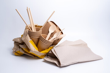Kraft paper tableware: cups, food boxes, isolated on a light background. A set of various disposable tableware. Recycling and zero waste concept. Mock up