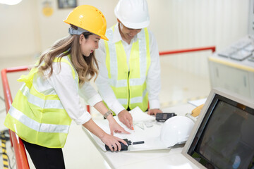 Industrial power plant construction plans are carefully reviewed by male and female engineers. Because they meticulously check every detail of Green Print.