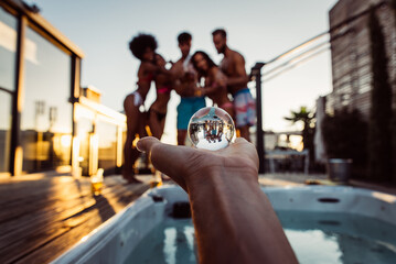 Group of friends having fun on the rooftop of a beautiful rooftop. Young people celebrating on a modern terrace with the view at the aperitif time. 