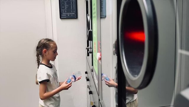 A girl sends aluminum cans and plastic bottles to a recycling machine