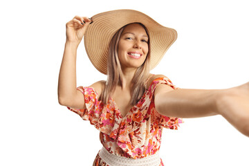 Smiling young woman in a dress and straw heat taking a selfie