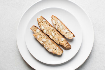 Overhead view of almond biscotti on a white plate, almond cantucci cookies on a white plate, flatlay of biscotti cookies or twice baked cookies