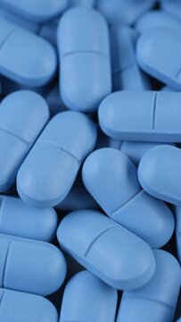 Heap of blue pills close up, slider shot. Pharmaceutical Industry