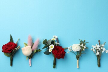 Many stylish boutonnieres on light blue background, flat lay. Space for text © New Africa