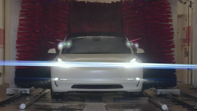 Electric Vehicle Washing by Automatic Car Wash Machine. Slow Motion