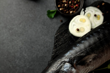 Dried mackerel herring on a black cutting board on a black background