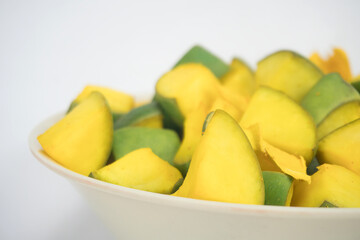 Half Bowl in left side View Of Slices of Mango for Mango Pickle In White Bowl, Isolated On Black Background