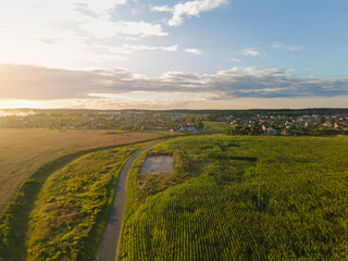 Panorama view from above of the summer landscape. Orange sunset sky, fields and forests, rivers and roads