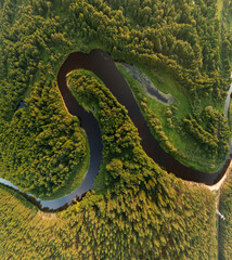 Panorama view from above of the summer landscape. Orange sunset sky, fields and forests, rivers and roads