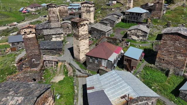 Aerial drone view of the Ushguli village with Svan towers in Svaneti region in Georgia. Medieval stone tower houses with Caucasus Mountains at background. Highest inhabited settlements in Europe