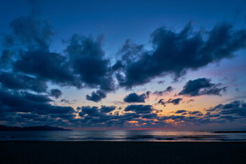 雲が迫り来る夕暮れ時の海岸