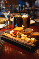 Cheese plate with breadsticks and sauces on the table in a restaurant or bar. A delicious snack.