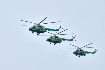Three Russian military helicopters armed with missiles flies in blue sky, airborne mission of gunships with targeting system performs an aerial maneuvers for military operation, russian aviation © TRAVELARIUM