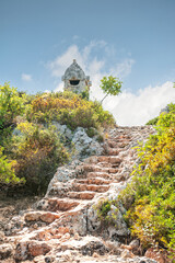 Ancient old ruined tombs on sunny day against cloudy sky