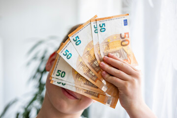 child holding euros, euro banknotes money in fan, euro money, rejoices in success, anticipates what...