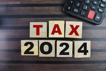 Concept of The wooden Cubes with the word Tax 2024 on wooden background.