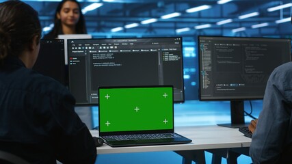 Manager in server hub supervising engineers looking for misconfiguration using isolated screen device. Woman coordinating experts mending data center bugs with mockup notebook, close up panning shot