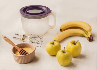 Milkshake (smoothie) and ingredients on the background of a bowl for a mixer