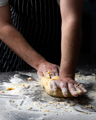 Beautiful and strong men's hands knead the dough make bread, pasta or pizza.
