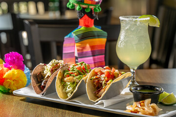 A Trio of Tasty Tacos - Suadero (braised brisket on blue corn tortilla), Grouper and Shrimp tacos with house-made salsa verde, grilled onion and lime, with a margarita.