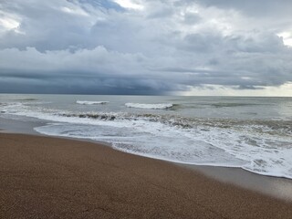 Dramatic weather, view, low dark blue clouds, waves on the sea, coastline, all awaiting of rain or storm