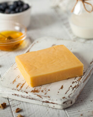 Craft cheese piece on rustic wooden board in kitchen