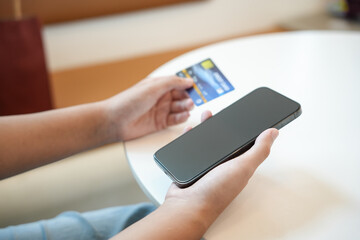 Asian woman with smart phone for online shopping.  Hand holding mobile phone with Payment on credit card online shopping electronic wallet Payment Shopping by phone connected card concept