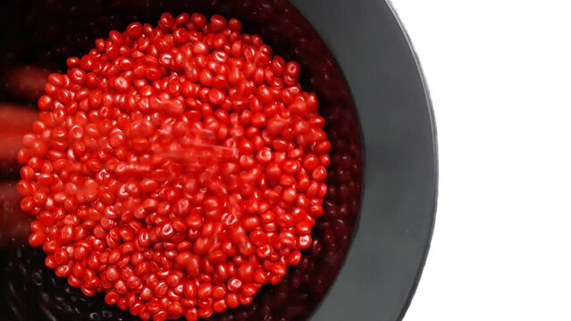 Red masterbatch granules fall into the black cup.Color pigment carrier polymer in the plastics industry