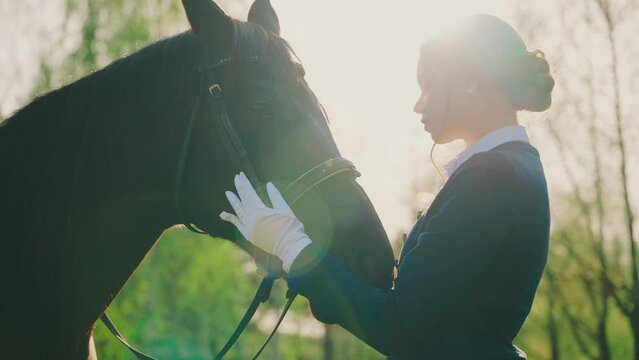 Portrait closeup happy young woman hugs her horse with love affection care noble lady enjoy walking nature divine sun rays light flare sky. Fantasy teen Girl jockey hand hold muzle black horse pet 4k