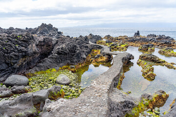 Characteristic volcanic formations next to the sea forming natural pools and water diversions, Faj&atilde; das Almas - S&atilde;o Jorge Island-Azores-Portugal