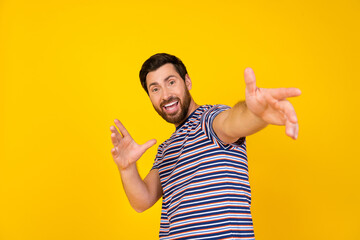 Portrait of overjoyed funky guy with bristle wear striped t-shirt dancing stretching hands to you...