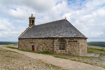 Fototapeta premium La chapelle du Mont Saint Michel de Brasparts, nichée au cœur du Parc d’Armorique dans les Monts d'Arrée, offre une vue panoramique exceptionnelle sur la Bretagne.