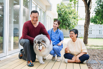 A man and a woman are sitting on a porch with a dog