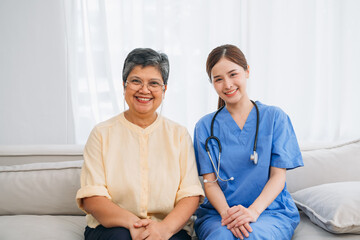 A woman in a yellow shirt is sitting on a couch with a nurse in a blue uniform