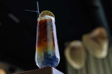 cold refreshing ice coffee in a transparent glass on a wooden table