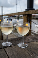 Tasting of Bordeaux white wine, right bank of Gironde Estuary, France. Glasses of white sweet French wine served in outdoor restaurant on oysters farm in Gujan-Mestras, Arcachon bay